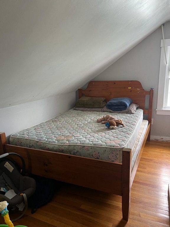 bedroom with vaulted ceiling and light wood-type flooring