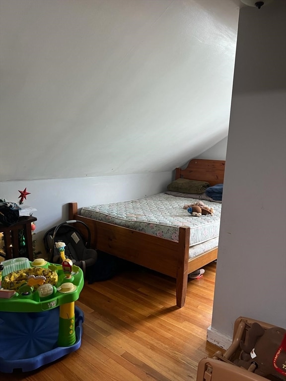 bedroom featuring lofted ceiling and light wood-type flooring