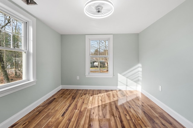 spare room featuring hardwood / wood-style flooring, a wealth of natural light, and ceiling fan