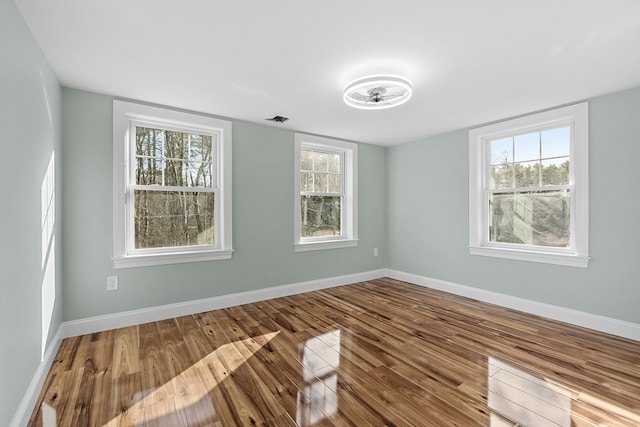 empty room featuring hardwood / wood-style floors and a healthy amount of sunlight