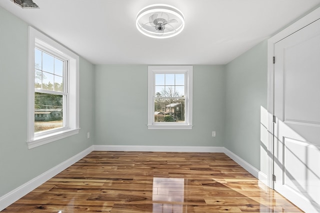 empty room with ceiling fan and hardwood / wood-style flooring