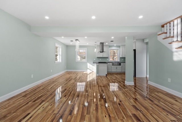 unfurnished living room featuring hardwood / wood-style floors and sink