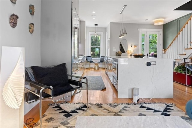 kitchen with light wood-style flooring, plenty of natural light, pendant lighting, and a center island