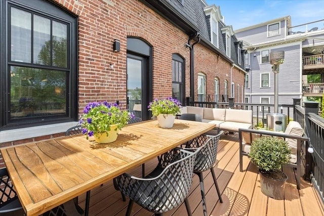 wooden terrace with outdoor dining space and an outdoor hangout area