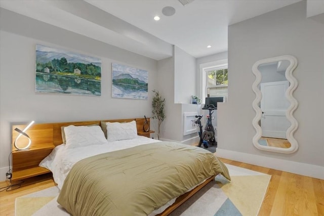 bedroom with wood finished floors, baseboards, and recessed lighting
