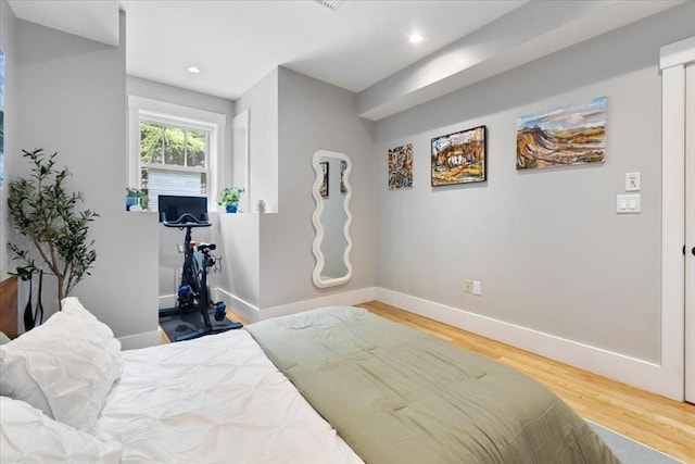 bedroom with wood finished floors, baseboards, and recessed lighting