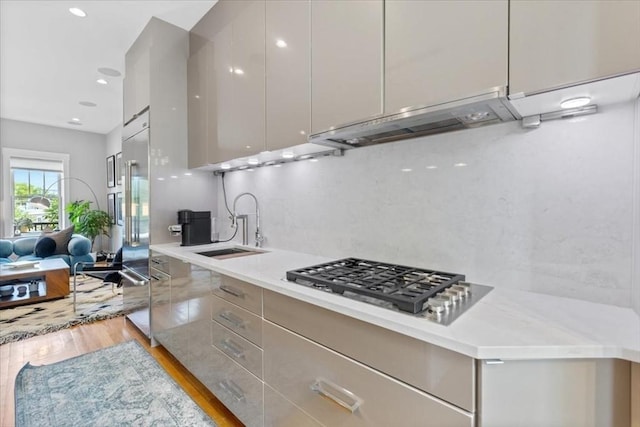 kitchen featuring modern cabinets, appliances with stainless steel finishes, a sink, light countertops, and recessed lighting