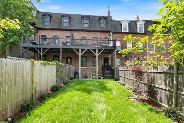 rear view of house with mansard roof, brick siding, and central air condition unit
