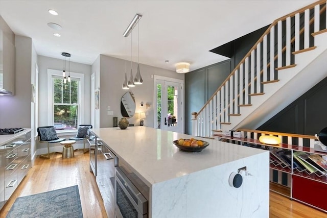 kitchen with stainless steel microwave, healthy amount of natural light, and light wood-style flooring