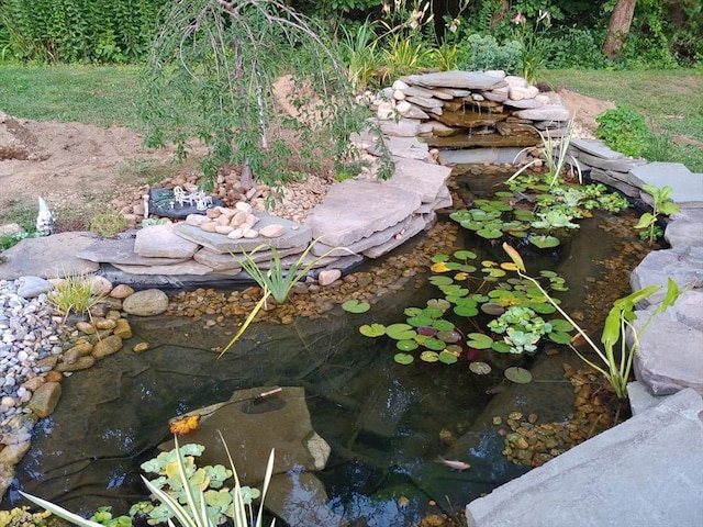 exterior details with a garden pond