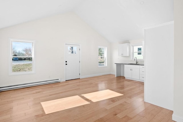 interior space featuring sink, high vaulted ceiling, light wood-type flooring, and a baseboard radiator