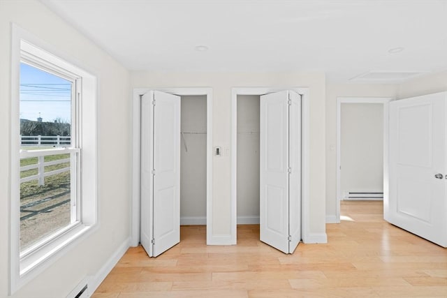 unfurnished bedroom featuring light hardwood / wood-style floors and a baseboard radiator