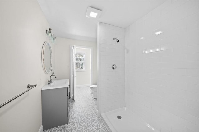 bathroom featuring tiled shower, vanity, and toilet