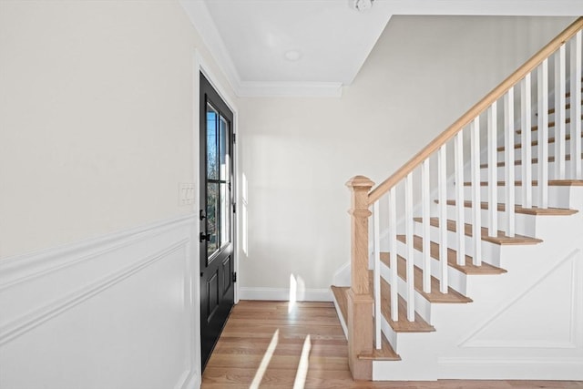 foyer entrance featuring crown molding and hardwood / wood-style floors