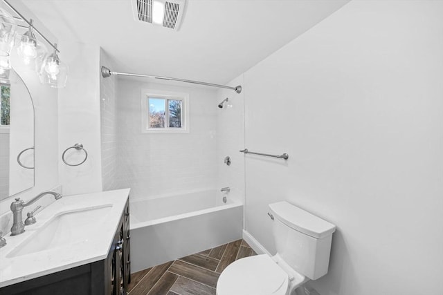 full bathroom featuring toilet, tiled shower / bath combo, and vanity