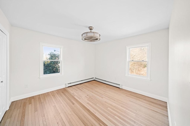 empty room with light wood-type flooring and a baseboard radiator