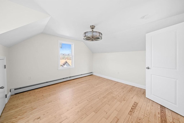 additional living space with lofted ceiling, baseboard heating, and light hardwood / wood-style floors