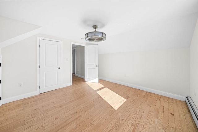 bonus room featuring baseboard heating, vaulted ceiling, and light hardwood / wood-style floors