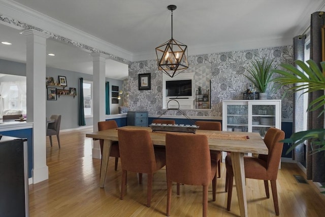 73 Sparrow Way, Raynham, MA 02767 - dining area featuring light wood-style flooring, wallpapered walls, decorative columns, baseboards, and an accent wall