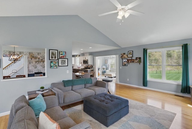 73 Sparrow Way, Raynham, MA 02767 - living area with baseboards, light wood-style flooring, and ceiling fan with notable chandelier