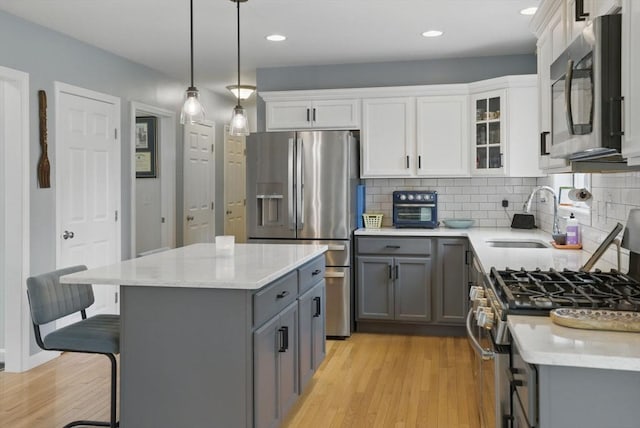 73 Sparrow Way, Raynham, MA 02767 - kitchen with light wood-type flooring, stainless steel appliances, gray cabinetry, and a sink