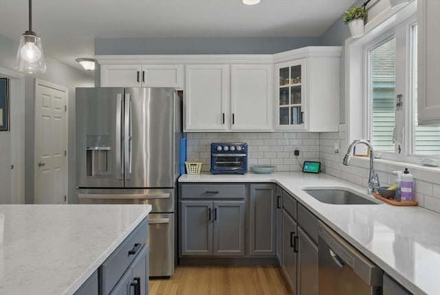 73 Sparrow Way, Raynham, MA 02767 - kitchen with a sink, stainless steel appliances, a healthy amount of sunlight, light wood-type flooring, and light stone counters