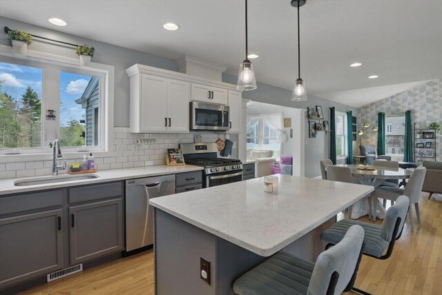 73 Sparrow Way, Raynham, MA 02767 - kitchen with a kitchen bar, a sink, stainless steel appliances, gray cabinetry, and recessed lighting