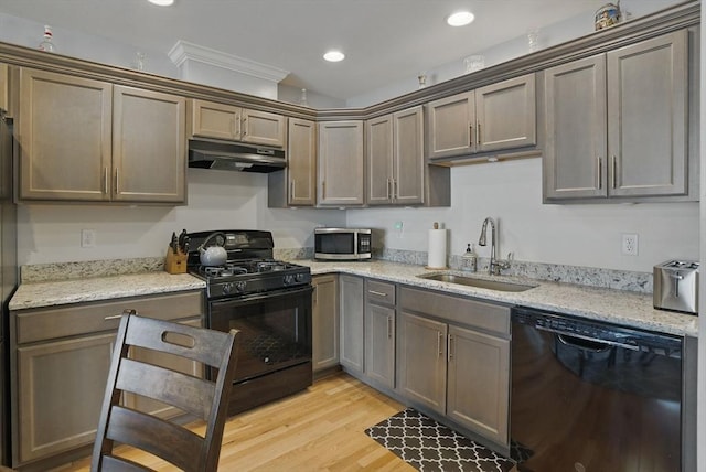 73 Sparrow Way, Raynham, MA 02767 - kitchen with light wood-style flooring, under cabinet range hood, light stone counters, a sink, and black appliances