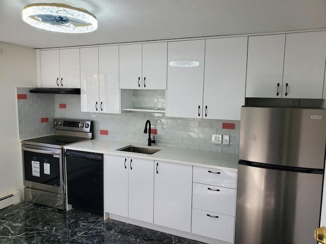 kitchen featuring sink, white cabinetry, tasteful backsplash, baseboard heating, and appliances with stainless steel finishes