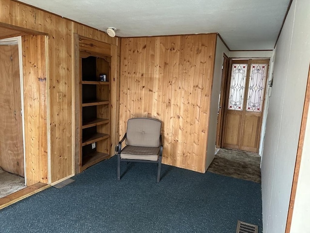 unfurnished room featuring wood walls, carpet floors, and ornamental molding