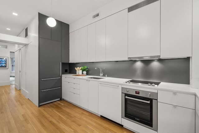 kitchen with sink, white cabinets, stainless steel oven, and black electric cooktop