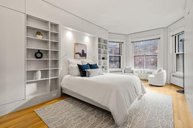 bedroom with radiator and hardwood / wood-style floors