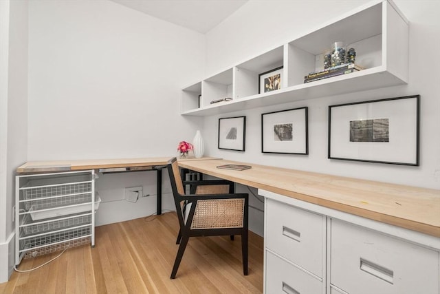 office with built in desk and light hardwood / wood-style floors