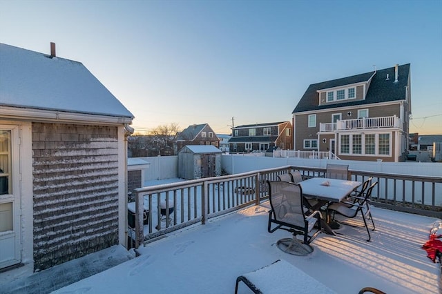 snow covered deck featuring a storage unit