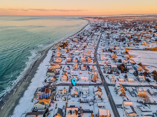 aerial view at dusk with a water view and a beach view