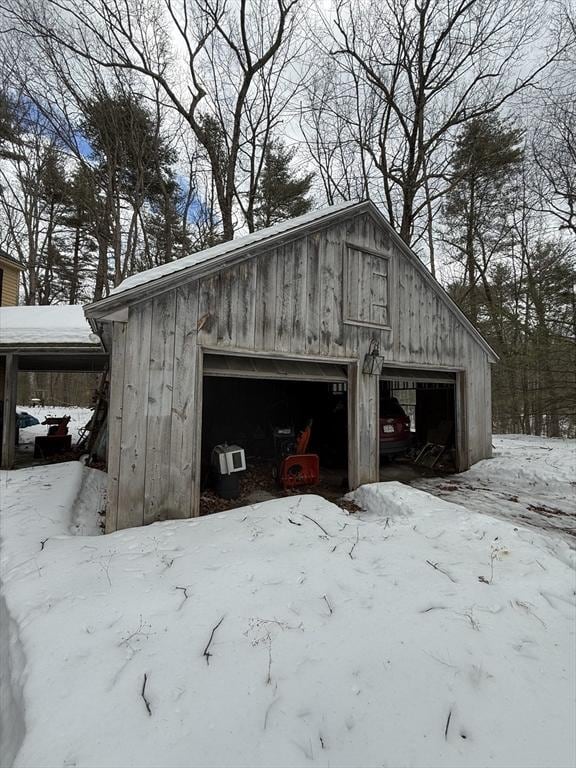 snow covered garage with a detached garage