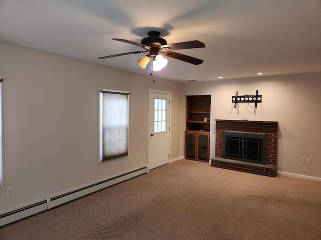 unfurnished living room with a baseboard radiator, carpet, ceiling fan, and a fireplace