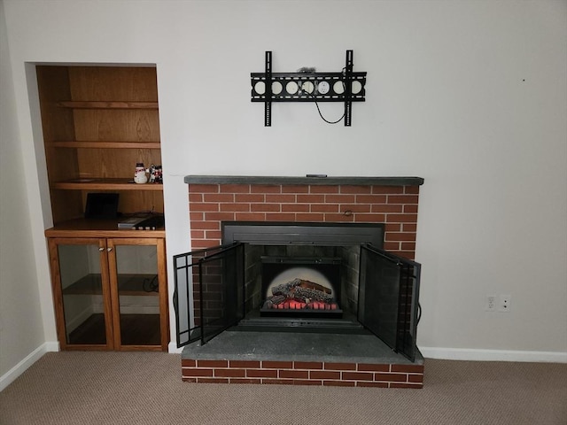 details featuring built in features, a brick fireplace, and carpet