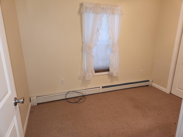 spare room featuring a baseboard radiator and light carpet