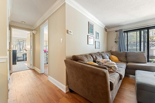 living room featuring crown molding, baseboards, a wealth of natural light, and light wood-type flooring