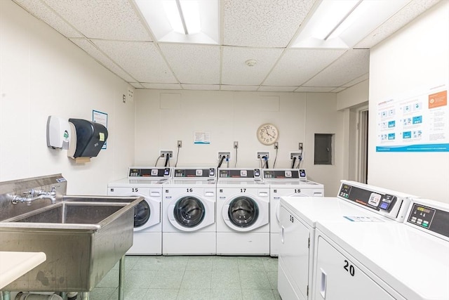 washroom with washing machine and dryer, electric panel, and sink