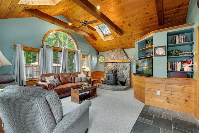14 Cottage St, Whitman, MA 02382 - living room with a skylight, a wood ceiling with exposed beams, ceiling fan, stone tile flooring, and a wood stove