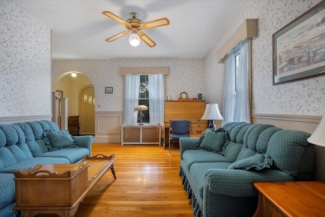 14 Cottage St, Whitman, MA 02382 - living area with wallpapered walls, wainscoting, radiator, light wood-style floors, and arched walkways