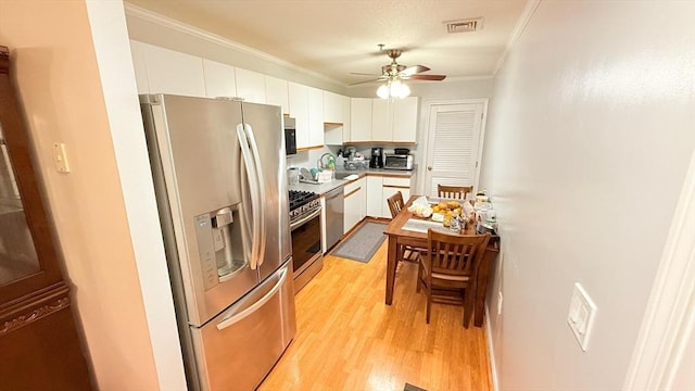 13 Dallas Dr Unit 308, Dracut, MA 01826 - kitchen featuring stainless steel appliances, crown molding, white cabinets, light wood-style flooring, and ceiling fan