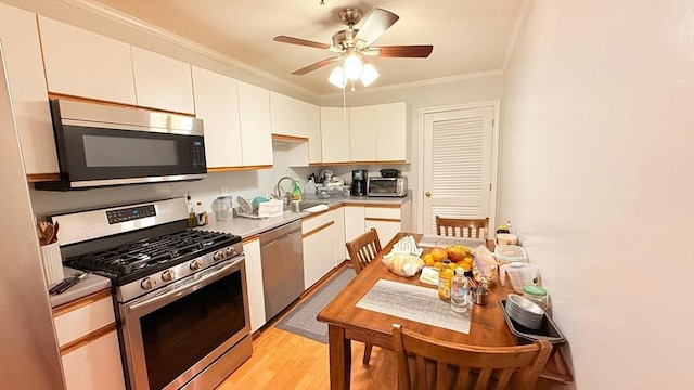 13 Dallas Dr Unit 308, Dracut, MA 01826 - kitchen with appliances with stainless steel finishes, white cabinets, crown molding, light wood-type flooring, and ceiling fan