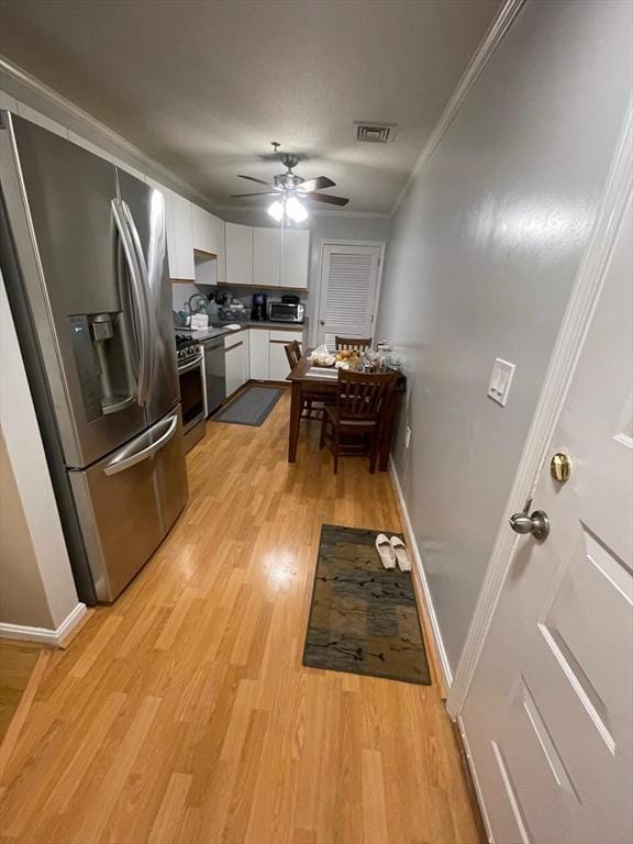 13 Dallas Dr Unit 308, Dracut, MA 01826 - kitchen featuring stainless steel appliances, light wood-type flooring, white cabinets, a ceiling fan, and crown molding