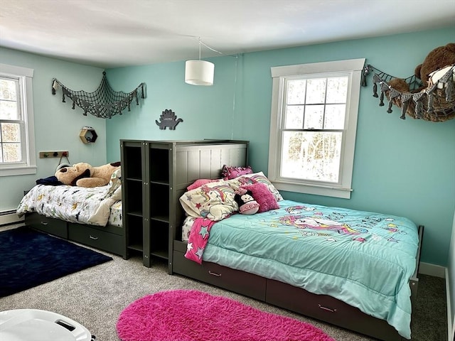 bedroom featuring a baseboard heating unit, carpet floors, and multiple windows