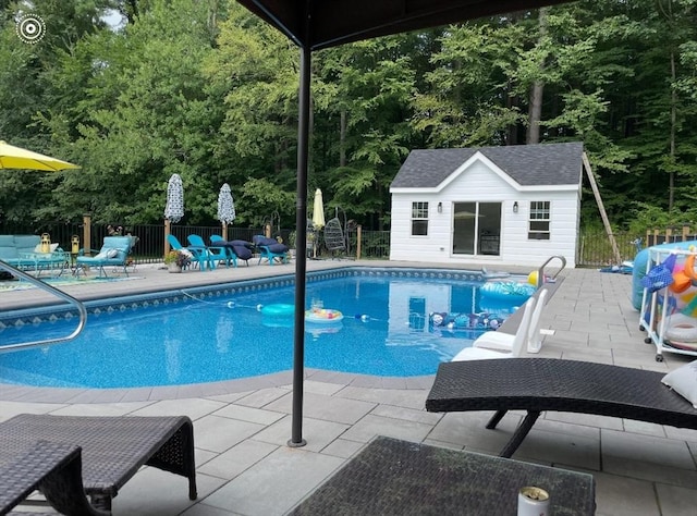 view of pool featuring a patio area and an outbuilding