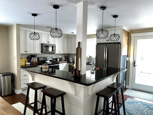 kitchen featuring decorative light fixtures, range with electric cooktop, tasteful backsplash, and stainless steel fridge