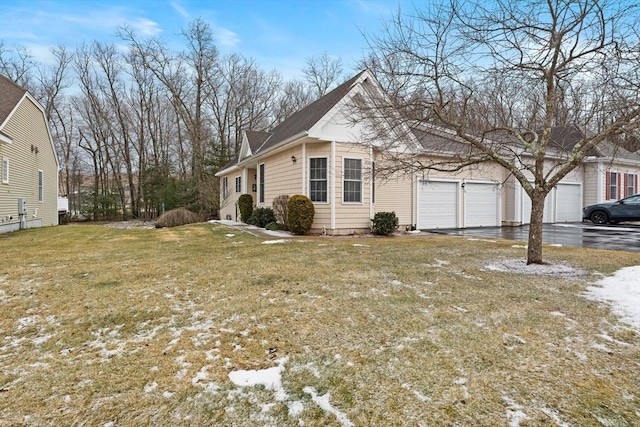 view of side of home with a garage and a lawn